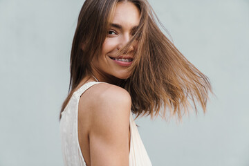 Fototapeta premium Image of young caucasian brunette woman wearing dress smiling at camera