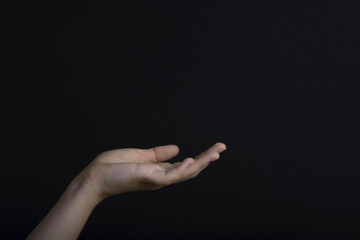 Hand gesture on a dark background. Female open hand
