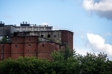 old red brick factory as a medieval fortress against a blue sky with clouds
