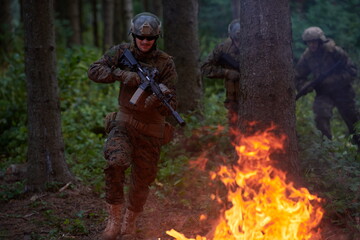 Soldier in Action at Night jumping over fire