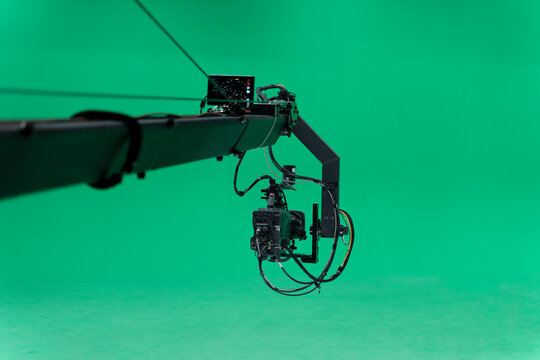 Broadcast television studio camera jib in greenscreen studio room on the ceiling.