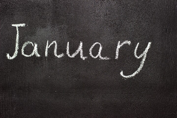 Month written in white chalk on a chalkboard. The month depicted on the chalkboard is January