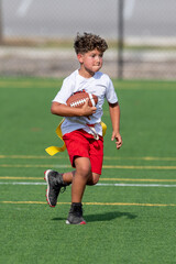 Cute athletic little boy playing excitedly in a flag football game