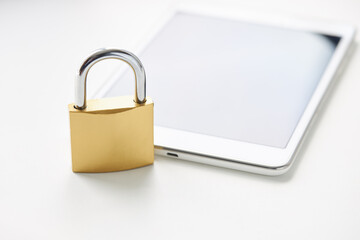tablet with padlock near it over white background. digital data security concept. virus protection software concept