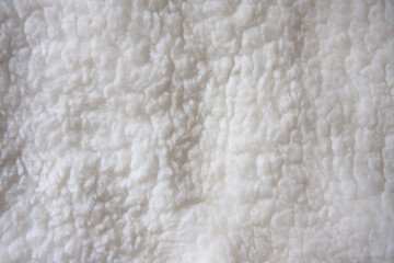 White soft wool background, detail of a natural merinosheepskin rug.