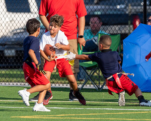 Cute athletic little boy playing excitedly in a flag football game