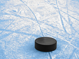 Puck on blue ice hockey rink surface