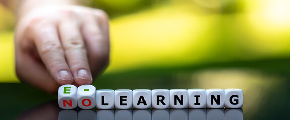 Hand turns dice and changes the expression "no learning" to "e-learning".