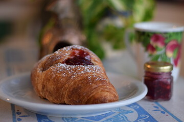 Un corazon de frambuesa dulce dentro de un croissant .