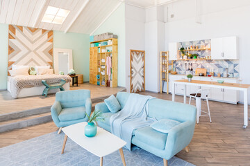 Fashionable spacious apartment with a stylish design in green, grey and white pastel colors with big window and decorative walls. bedroom and kitchen space