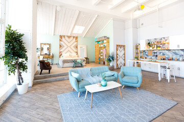 Fashionable spacious apartment with a stylish design in green, grey and white pastel colors with big window and decorative walls. bedroom and kitchen space