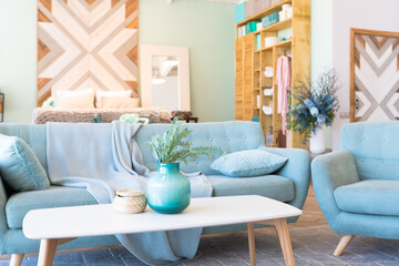 Fashionable spacious apartment with a stylish design in green, grey and white pastel colors with big window and decorative walls. bedroom and kitchen space