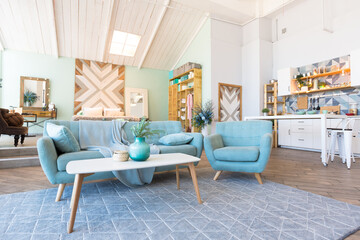 Fashionable spacious apartment with a stylish design in green, grey and white pastel colors with big window and decorative walls. bedroom and kitchen space