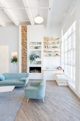 Fashionable spacious apartment with a stylish design in green, grey and white pastel colors with big window and decorative walls. bedroom and kitchen space