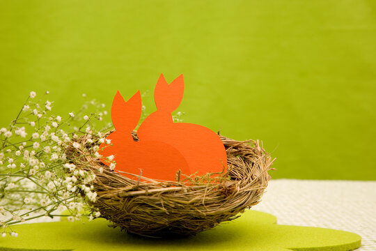 Osterhasen aus orangenem Papier vor Gr&uuml;n