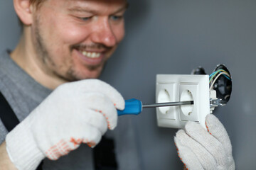 Handyman using screwdriver to install sockets
