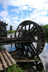 old wooden wheel on the abandoned watermill on the river landscape