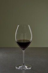 Rotwein im Glas auf dunklem Stein Tisch mit grünem Hintergrund