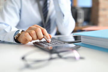 Hand of male businessperson making calculations