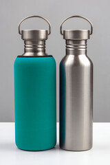 metal steel water flasks on gray background. metal drinking utensils