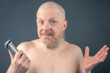Bearded man with trimmer to adjust beard in hand. grooming and fashionable style barbershop. Beard length correction