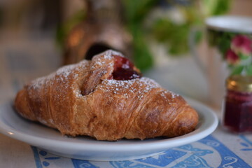 Un corazon de frambuesa dulce dentro de un croissant .