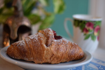 Un corazon de frambuesa dulce dentro de un croissant .