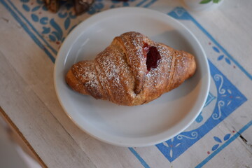 Un corazon de frambuesa dulce dentro de un croissant .