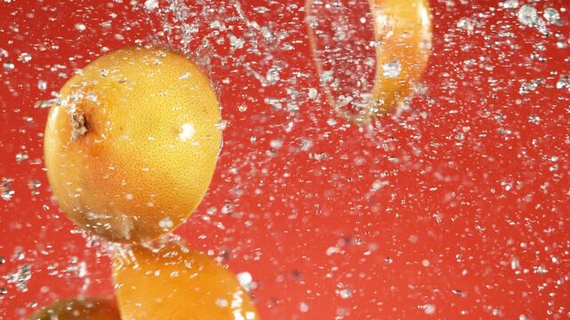 Super slow motion of grapefruit slices collision with water splashes. Filmed on high speed cinema camera, 1000 fps.