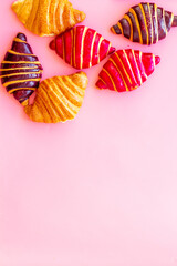 Set of croissants - chocolate, berry, classic - on pink desk top view