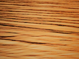 wavy surface of water with gold sunset colour