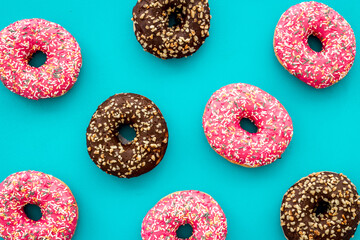 Donuts flat lay pattern on blue background, top view
