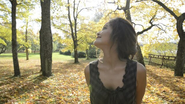 Young beautiful Asian woman with autumn trees in the forest