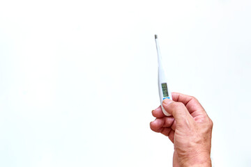 Old man's hands holding digital thermometer to measure body temperature. Means of coronavirus prevention and treatment. Covid-19. Health concept.
