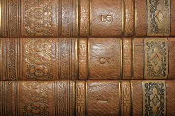 Close up of a set of three numbered books with a leather kaft which are old and displaying flowers