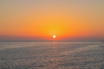 The orange sun sets over the horizon. Atlantic Ocean. Spain