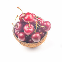 juicy cherry berry in a bowl of coconut on a white background. fruits and vitamins. healthy food for breakfast. fruits of vegetation. fruit dessert