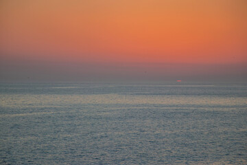 The orange sun sets over the horizon. Atlantic Ocean. Spain