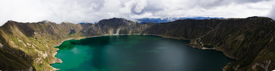 A panoramic view over the famous blue green Quilotoa lake in an old vulcano crater that can be found in the Andes of Ecuador, South America