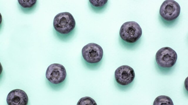 Macro shot blueberry pattern appear and disappear on blue background from adobe. Stop motion animation. Food and vegetarian concept 