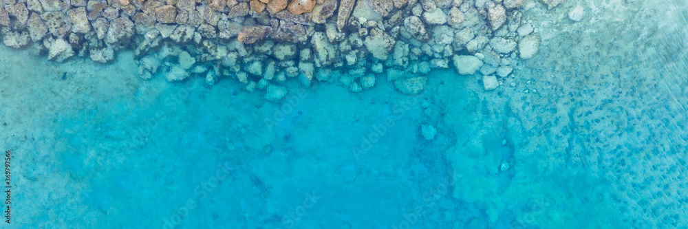 Wall mural An aerial view of the beautiful Mediterranean Sea, where you can see   the cracked rocky textured underwater corals and the clean turquoise water of Protaras, Cyprus,  - Wall murals