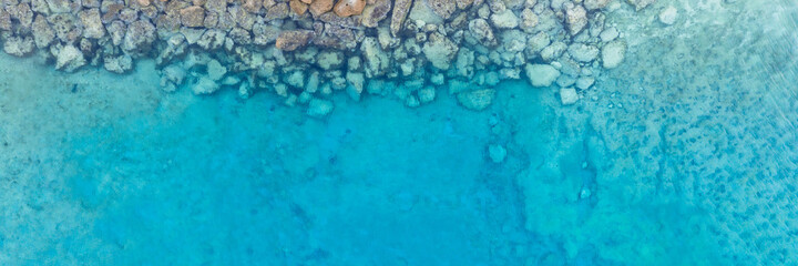 An aerial view of the beautiful Mediterranean Sea, where you can see   the cracked rocky textured underwater corals and the clean turquoise water of Protaras, Cyprus, 