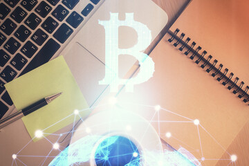 Blockchain theme hologram drawings over computer on the desktop background. Top view. Double exposure.