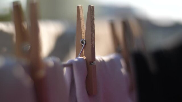 Closeup on clean laundry drying on a wire, gently moved by the wind, housework concept 