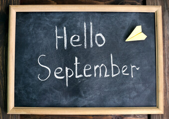 Chalk writing on a slate board. Hello September.