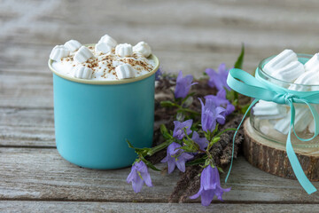 Morning coffee drink with marshmallow slices on a wooden background.