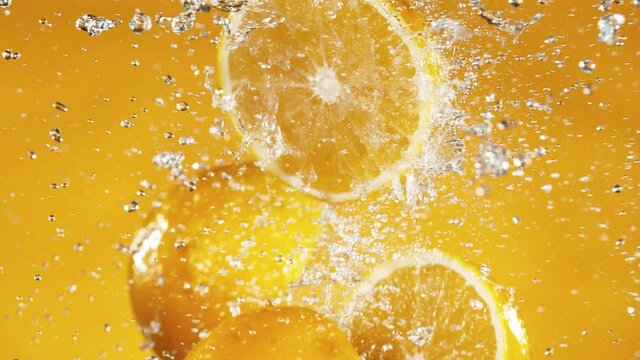 Super slow motion of orange slices collision with water splashes. Filmed on high speed cinema camera, 1000 fps.