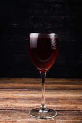 glass of red wine on wooden background