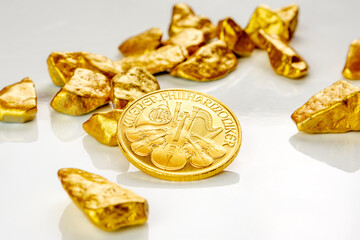 golden austrian philharmoniker one ounce coin laying on a heap of golden nuggets, golden ore