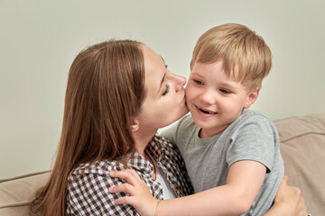 A loving young mother kisses her son on the cheek. A happy family. Mother day.